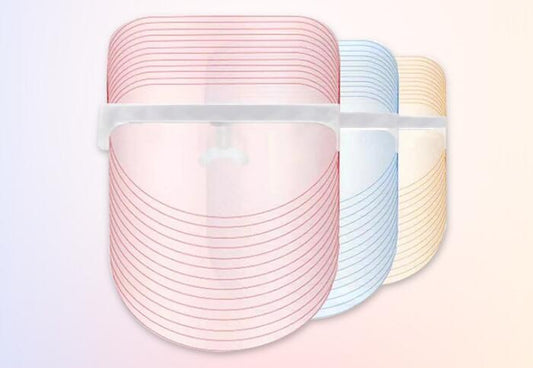 Three cylindrical containers with pink, blue, and beige lids on a light pink background